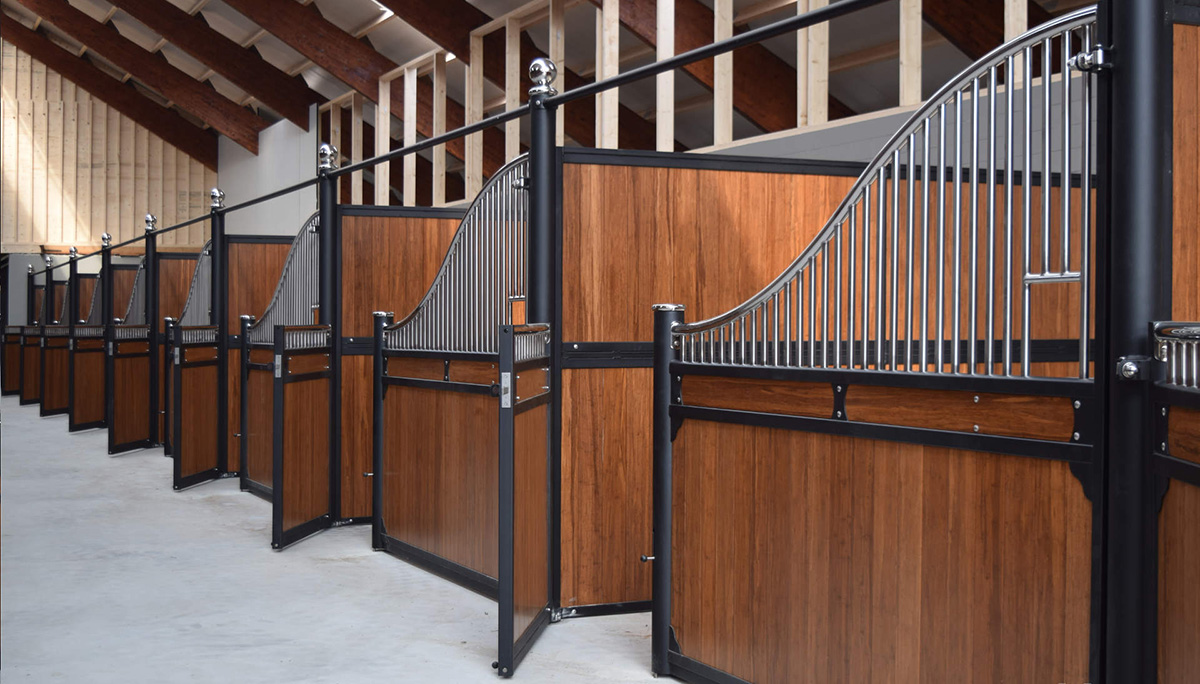 stable showing open stable panel gates on timber with steel curved frames and a cement floor