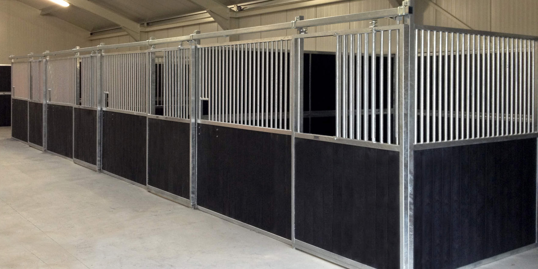 series of black plastic and steel stable panels on cement floor